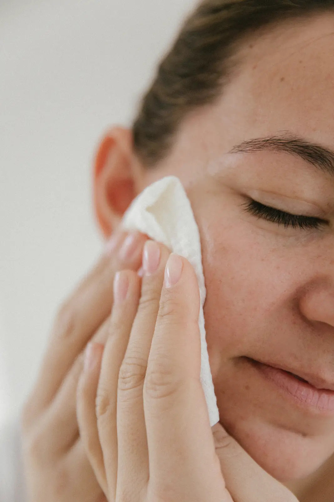 Mujer secando suavemente su rostro con Bambora
